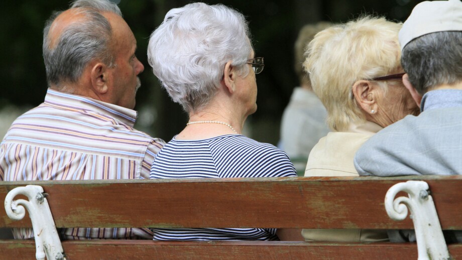 Elderly back sitting on a bench.