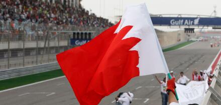 A marshal celebrates waving Bahrain flag after the Bahrain Formula One Grand Prix at the Formula One Bahrain International Circuit in Sakhir, Bahrain, Sunday, April 22, 2012. (AP Photo/Luca Bruno)