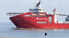 A man watching a Norwegian Deepwater Subsea Equipment Support Vessel (SESV), Aker Wayfarer, depart Eemshaven in the Netherlands
