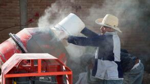 San Sebastian Abasolo, Oaxaca, Mexico - Workers mix cement to pave a formerly dirt street in a small rural town of Mexico.