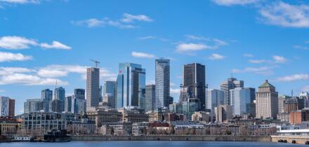 Montreal, Canada - April 4, 2025: A scenic view of Montreal's skyline from the St. Lawrence River, featuring urban architecture against a bright sky