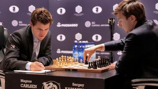 Sergey Karjakin, right, makes a move during round 8 of the World Chess Championship against Magnus Carlsen, in New York, Monday, Nov. 21, 2016. (AP Photo/Richard Drew)