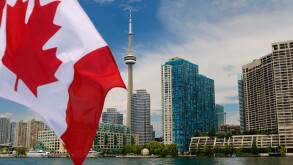 Canadian flag on boat leaving Toronto skyline and harbourfront on Lake Ontario
