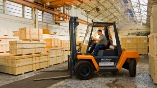 Warehouse - Man driving forklift truck, UK