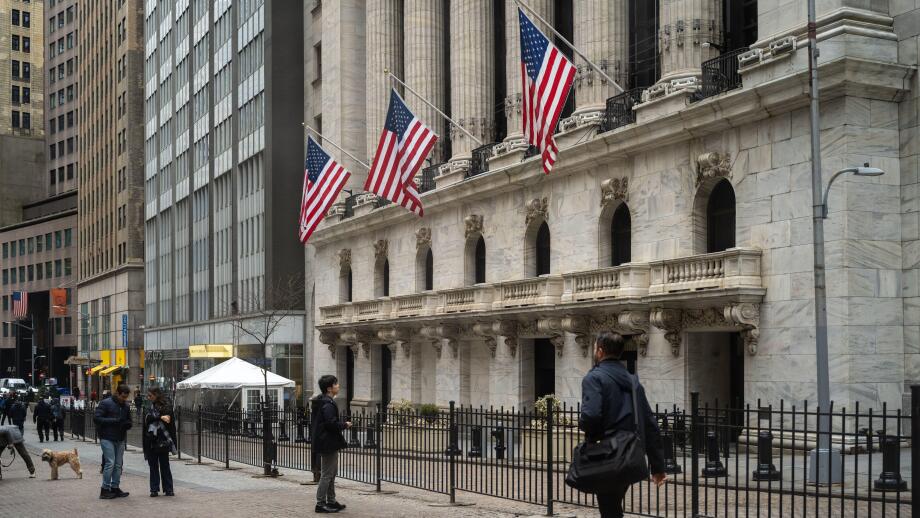 People walk past the New York Stock Exchange (NYSE) on Wall Street on March 4, 2026 in New York.