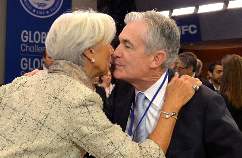 Federal Reserve Chairman Jerome Powell embraces former International Monetary Fund (IMF) Managing Director Christine Lagarde, now confirmed as the next president of the European Central Bank (ECB), as they meet for the International Monetary Finance Commi