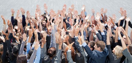 Crowd of business people cheering with arms raised