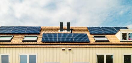 Row of new Dutch houses with solar panels and air-source heat pumps