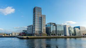 A scenic view of a glass buildings and the river in the modern part of Dublin Docklands, Ireland.