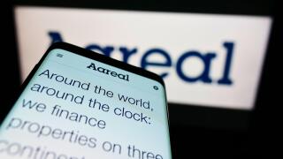 Mobile phone with website of German financial company Aareal Bank AG on screen in front of business logo. Focus on top-left of phone display.