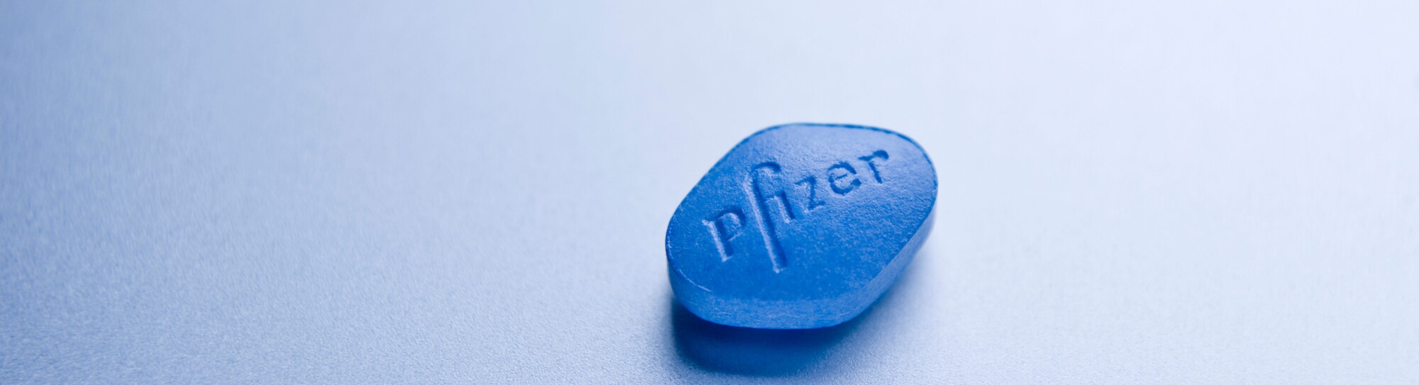 Close up Detail of a 100mg Sildenafil Citrate Pfizer Viagra Pill on silver background