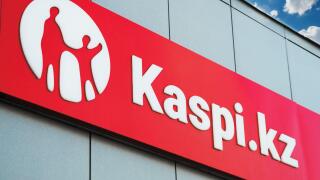 A signboard with the Kaspi Bank logo on the building above the entrance group