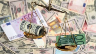 Unbalanced scales with dollar and euro banknotes