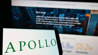 Smartphone with logo of US investment company Apollo Global Management Inc. on screen in front of website. Focus on center-left of phone display.