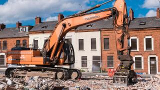 A demolition excavator on an inner city site where houses are being demolished.