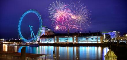 Fireworks sparkling in London sky next to river Thames and famous Ferris wheel. Festivity in the United Kingdom