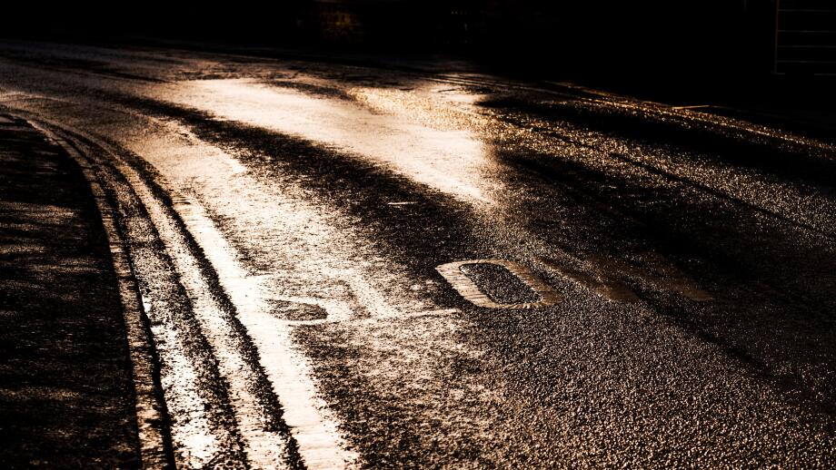 Slow sign painted on a road in Bugbrooke, Northamptonshire in low winter sun light