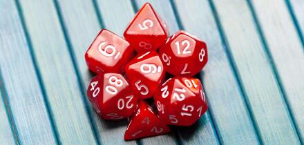 Lots of simple red RPG game dice, polyhedral dice set for role playing games and scenarios, top view. Dices group closeup. Tabletop board games