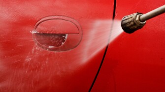 Cleaning the car with a pressure washer at jet wash
