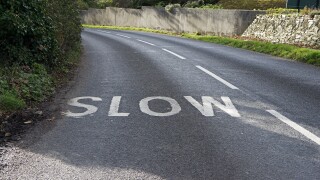 a slow sign painted in the road near a bend, uk