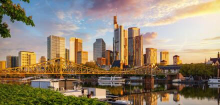 Golden sunrise view of the skyline of Frankfurt am Main, Germany, with banking skyscrapers, Eiserner Steg Bridge and River