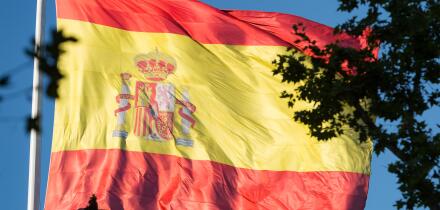 Huge Spanish flag blowing in the breeze in a square in Madrid, Spain