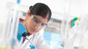 Young woman scientist  pipetting sample into vial in a laboratory used for chemical and DNA testing