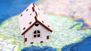 Wooden house model on background of US map. American housing market, purchase or rental of real estate in USA