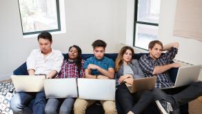 Tired business people using laptop while reclining on sofa in office