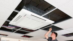 electrician installing air conditioning unit in suspended ceiling