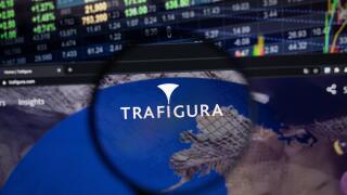 Trafigura company logo on a website with blurry stock market developments in the background, seen on a computer screen through a magnifying glass