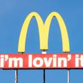 McDonald's logo arches sign and I'm Lovin' It slogan against blue sky with copy space