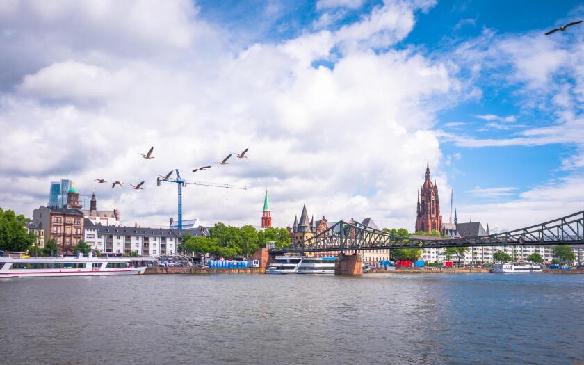 Summer panorama of the financial district with sky towers reflected on the river surface in Frankfurt am Main, Germany