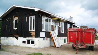 Home renovations: old house with siding removed on new styrofoam foundations