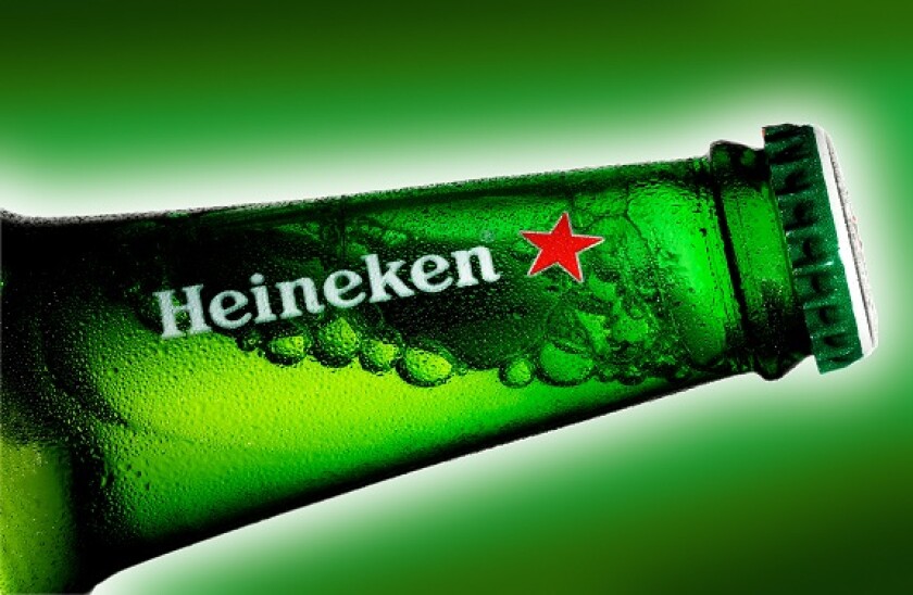 Close up of bottle of Heineken, green background