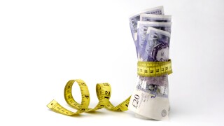 £20 notes being squeezed by a tape measure