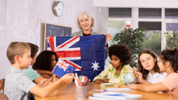 students listen to woman teacher who talks about Australia