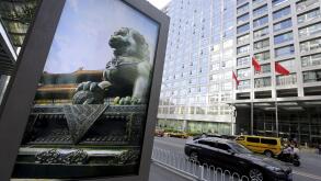 An advertising board (L) showing a Chinese stone lion is pictured near an entrance to the headquarters (R) of China Securities Regulatory Commission (CSRC), in Beijing, China, September 7, 2015.   REUTERS/Jason Lee/File Photo