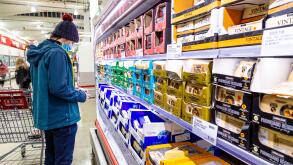 Man wearing a face mask, looking at prices at a supermarket during aftermath of Coronavirus pandemic, rising inflation and cost of living crisis