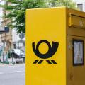 German yellow post box with Deutsche Post logo on city street