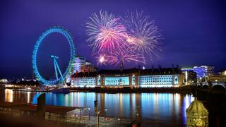 Fireworks sparkling in London sky next to river Thames and famous Ferris wheel. Festivity in the United Kingdom