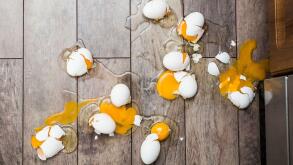 Lot of broken eggs on brown home floor. Misfortune concept.