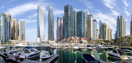 Dubai Marina skyline cityscape with yachts skyscraper real estate buildings living at water panorama boats