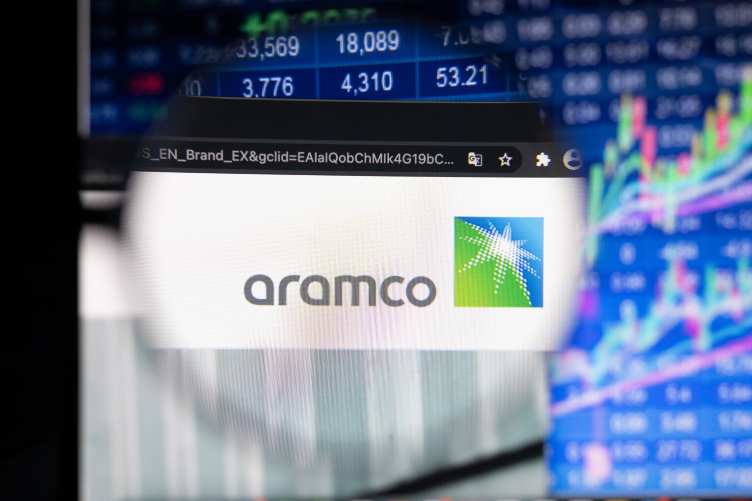 Aramco company logo on a website with blurry stock market develo