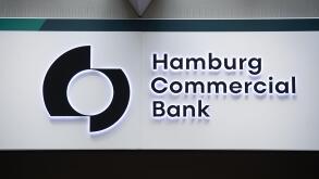 06 July 2021, Hamburg: The logo of Hamburg Commercial Bank can be seen on the bank's branch at Gerhart-Hauptmann-Platz. The Cologne public prosecutor's office searched rooms of the former HSH Nordbank in the course of the Cum-Ex scandal on 06.07.2021. Thi