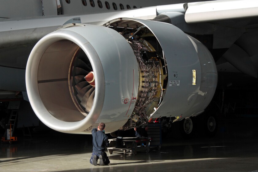 A technician carries out maintenance on a Rolls-Royce Trent 500 aircraft jet engine. Aviation engineering, knowledge workers, skilled workforce.