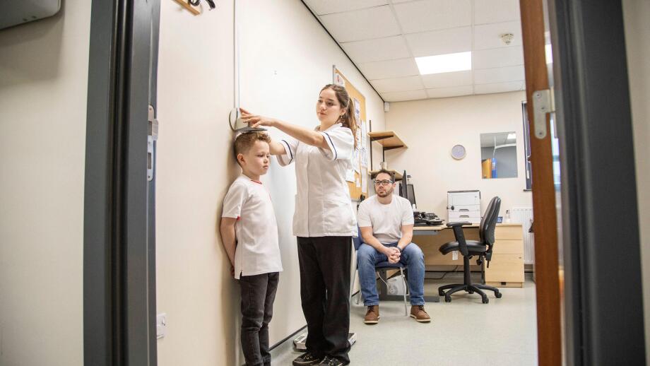 Medical professional measuring a child's height