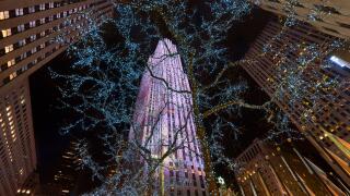 Night view of Rockefeller Center skyscrapers and Plaza illuminated with Winter holiday lights. Manhattan, New York City