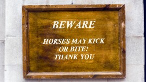 Beware, horses may kick or bite warning sign outside Horse Guards Parade on Whitehall, London, UK