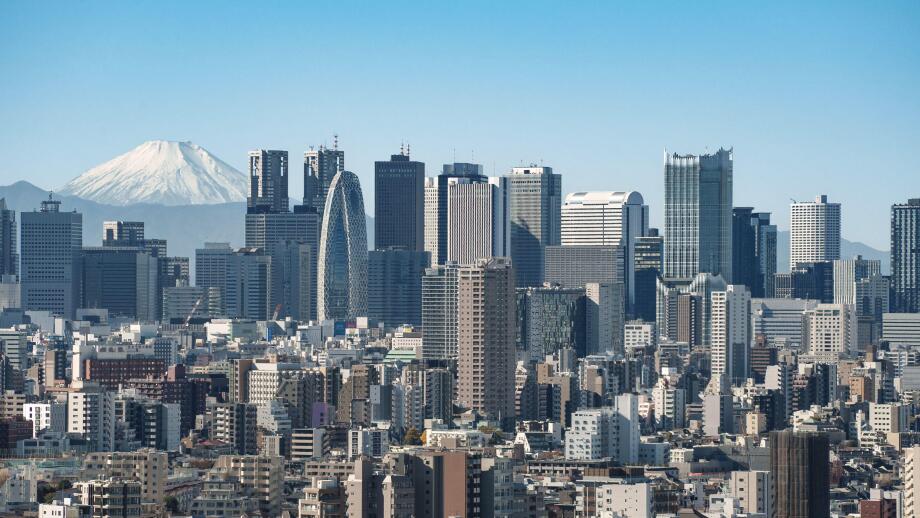 The view of the skyscrapers of Shinjuku and central Tokyo with the snow-covered peak of Mount Fuji in the distance.